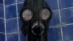 Latex-Dame mit schwarzer Gasmaske steht unter der Dusche und wird nass