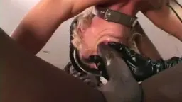 Blonde Latex-Hure in schwarzer Uniform saugt gierig an einem großen schwarzen Schwanz