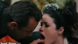 Devote Latex-Zofe blickt mit großen Augen nach oben zum dominanten Meister